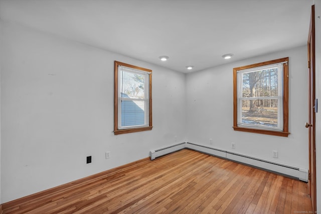 unfurnished room with light hardwood / wood-style flooring and baseboard heating