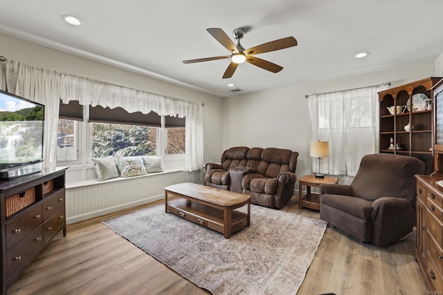 living room featuring light hardwood / wood-style floors and ceiling fan