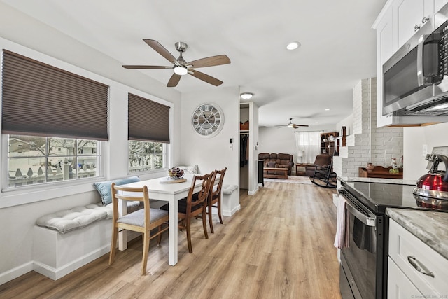 dining space with light hardwood / wood-style flooring and ceiling fan