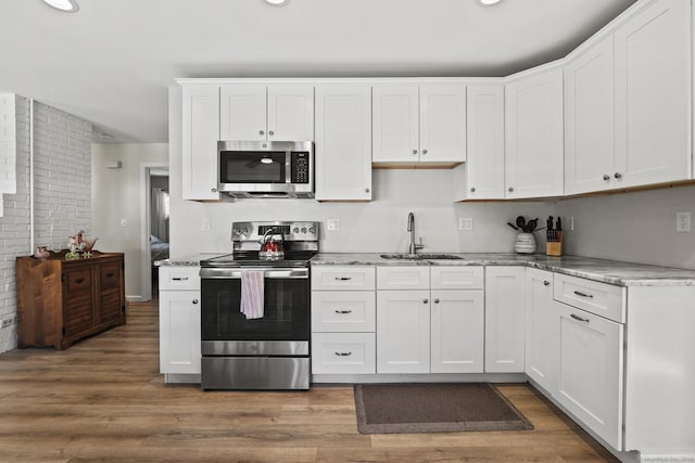 kitchen featuring stainless steel appliances, sink, white cabinets, and dark hardwood / wood-style flooring