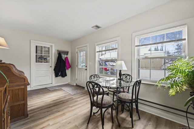 dining room featuring a baseboard heating unit and hardwood / wood-style floors