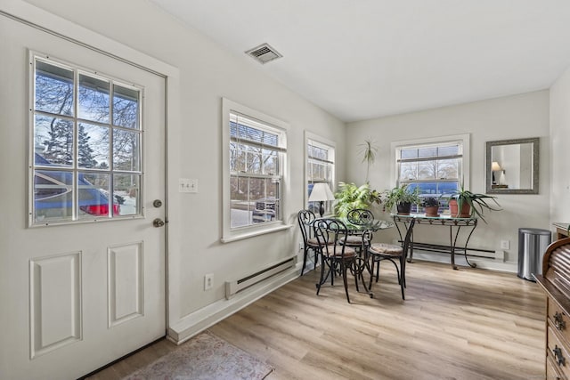 dining space with a baseboard radiator and light hardwood / wood-style floors