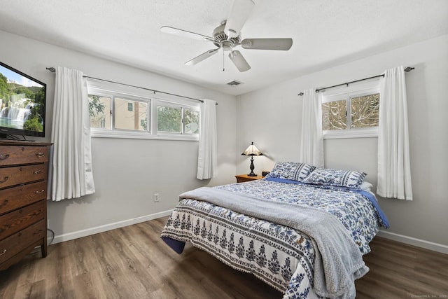 bedroom with hardwood / wood-style flooring, a textured ceiling, and ceiling fan