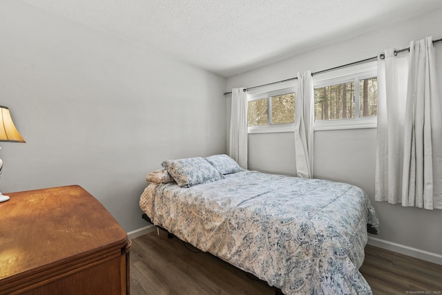 bedroom featuring dark wood-type flooring and a textured ceiling