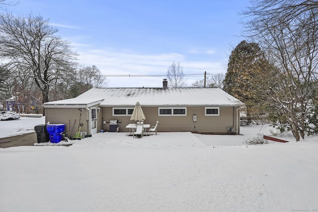 view of snow covered back of property