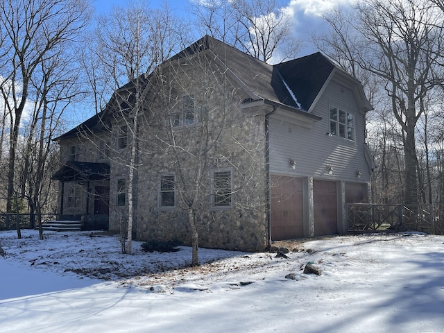 view of snow covered exterior with a garage