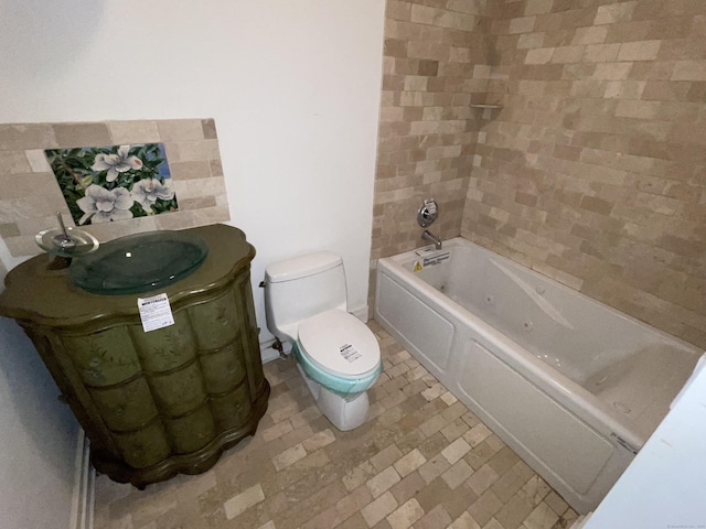 bathroom featuring a tub to relax in, toilet, and sink