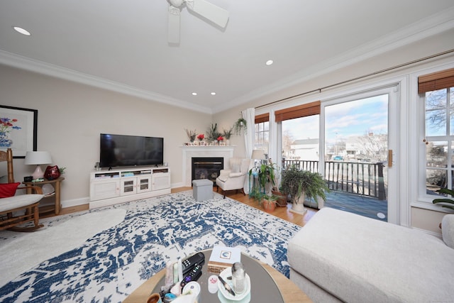 living room featuring hardwood / wood-style flooring, ornamental molding, and a wealth of natural light