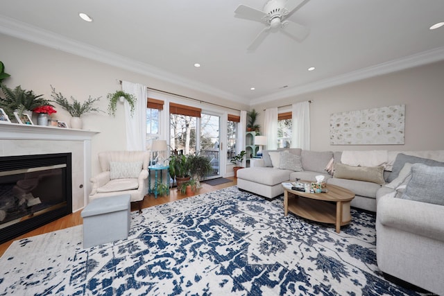 living room with wood-type flooring, ceiling fan, and crown molding