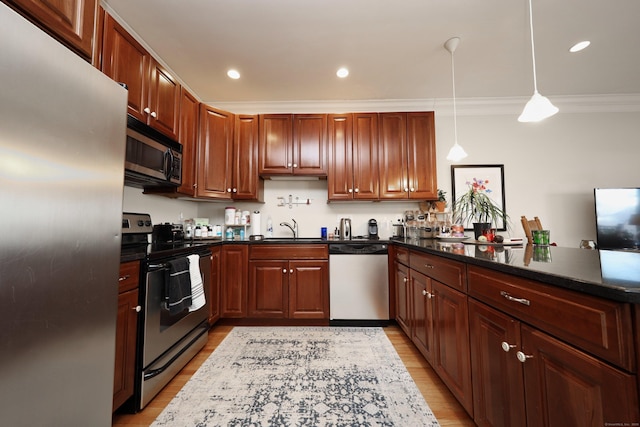 kitchen with sink, hanging light fixtures, light hardwood / wood-style floors, stainless steel appliances, and crown molding