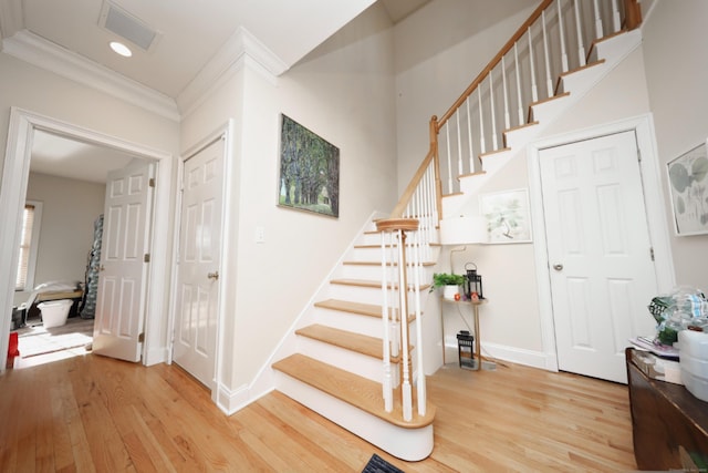 stairs featuring hardwood / wood-style flooring and crown molding