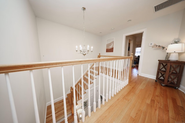 hallway featuring an inviting chandelier and hardwood / wood-style floors