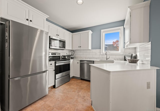 kitchen featuring backsplash, appliances with stainless steel finishes, sink, and white cabinets