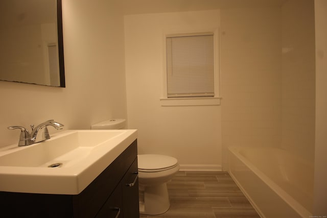 bathroom with vanity, a bathing tub, wood-type flooring, and toilet