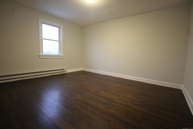 spare room featuring dark hardwood / wood-style flooring and baseboard heating