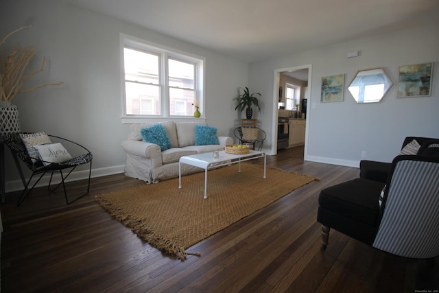 living room featuring dark wood-type flooring and a wealth of natural light