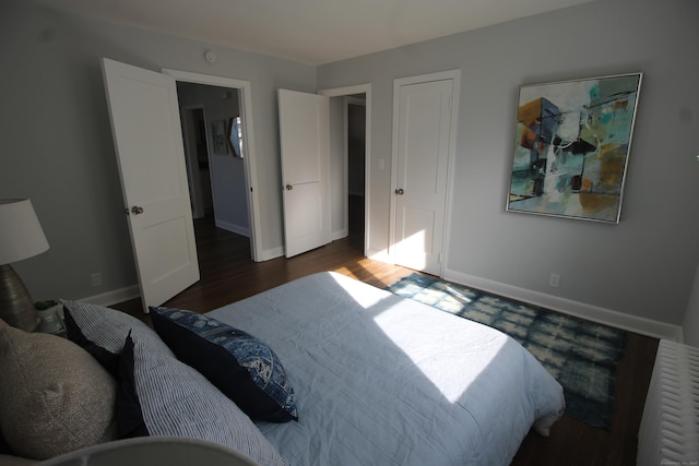 bedroom with dark hardwood / wood-style floors