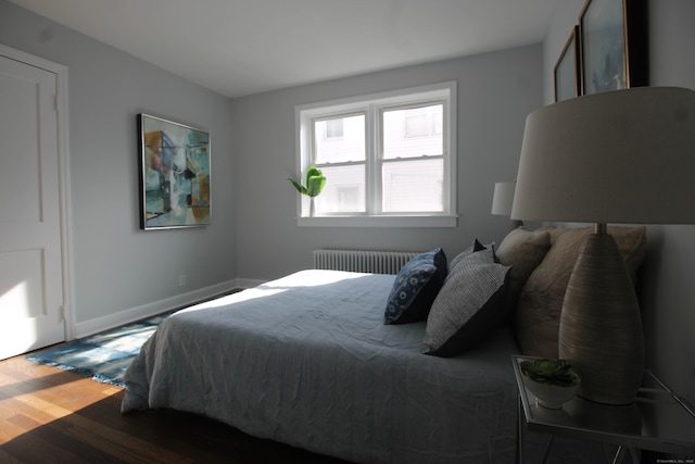 bedroom featuring radiator and hardwood / wood-style flooring