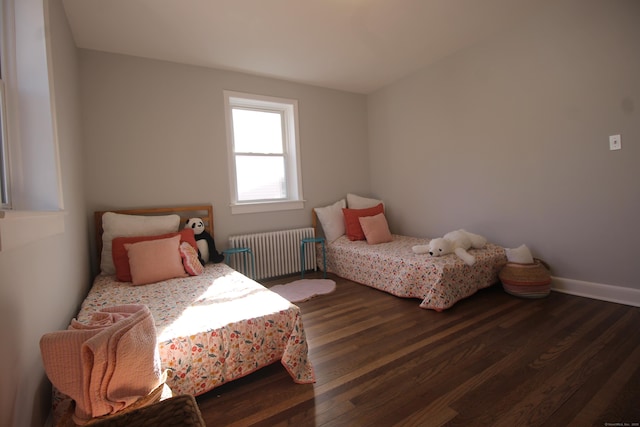 bedroom with radiator and dark hardwood / wood-style floors