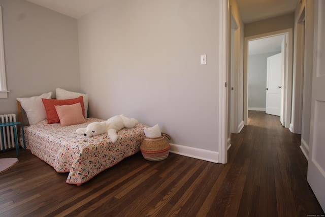 bedroom featuring radiator and dark hardwood / wood-style floors