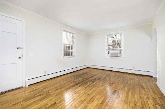 empty room featuring wood-type flooring, a healthy amount of sunlight, and crown molding