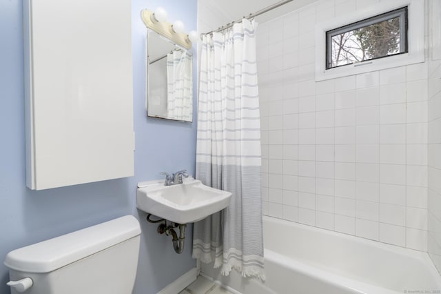 bathroom featuring shower / bath combination with curtain and toilet