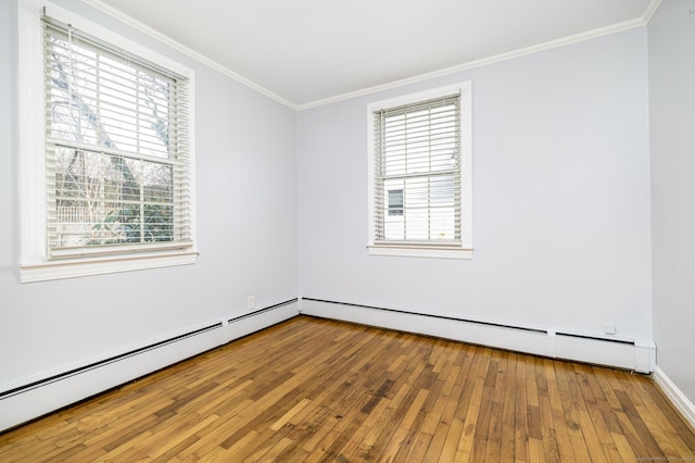 spare room with crown molding, a baseboard radiator, and wood-type flooring