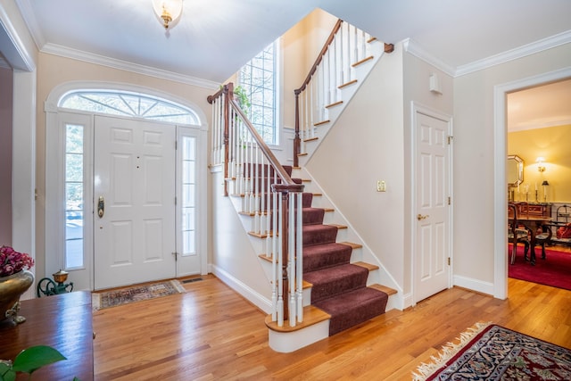 entryway featuring a wealth of natural light, light hardwood / wood-style flooring, and ornamental molding