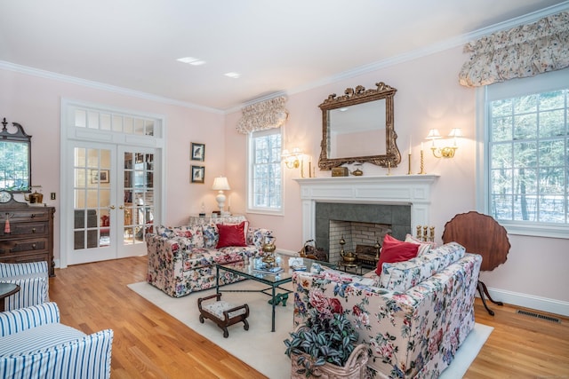 living room with french doors, crown molding, and light hardwood / wood-style floors