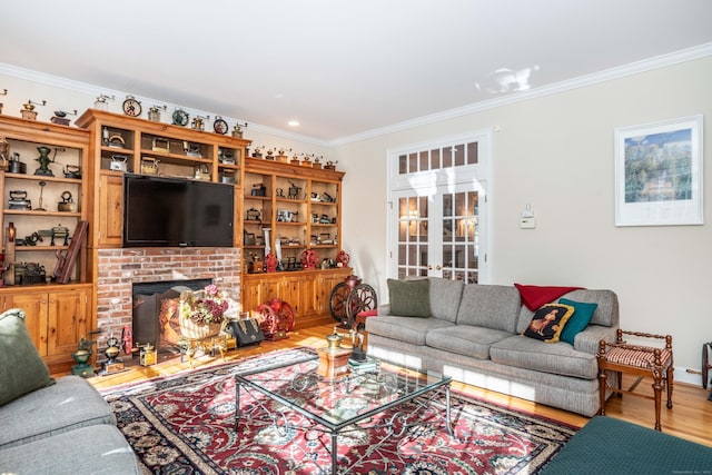 living room featuring hardwood / wood-style flooring, ornamental molding, a fireplace, and french doors