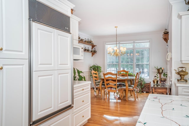 dining room featuring ornamental molding, light hardwood / wood-style floors, and a chandelier