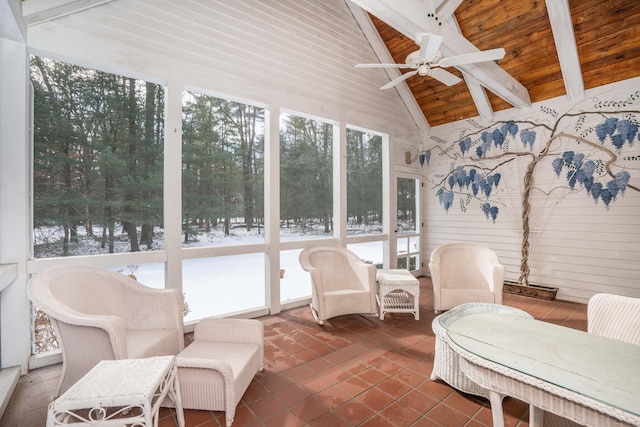 sunroom with lofted ceiling with beams, ceiling fan, and wood ceiling