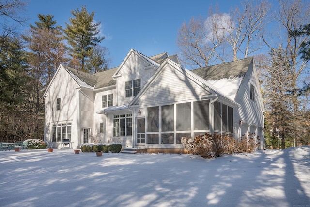 snow covered house with a sunroom