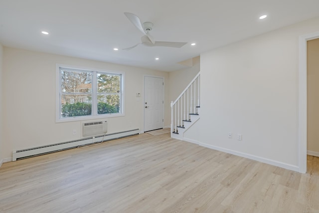 interior space featuring ceiling fan, a baseboard radiator, light hardwood / wood-style flooring, and an AC wall unit