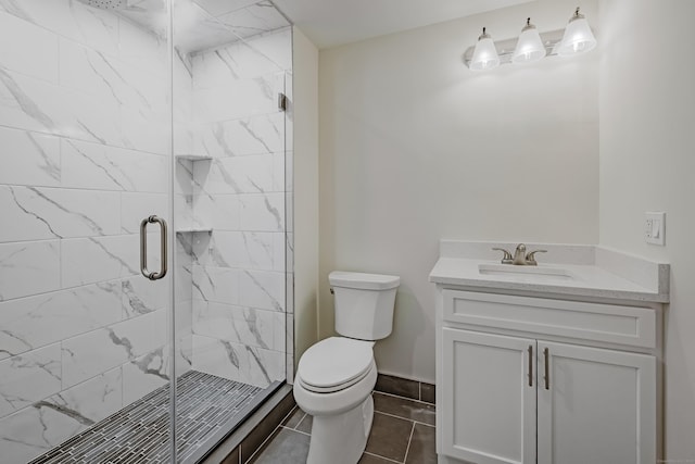 bathroom featuring vanity, a shower with shower door, and toilet