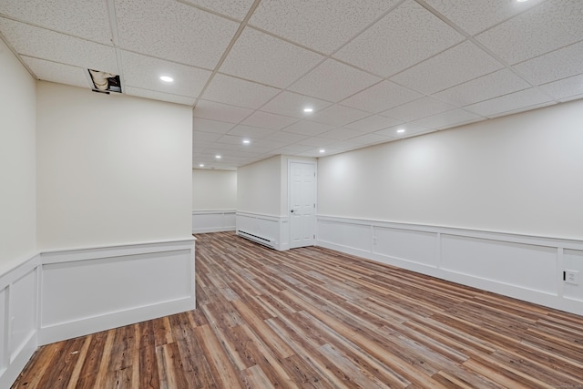 unfurnished room featuring hardwood / wood-style floors and a baseboard radiator