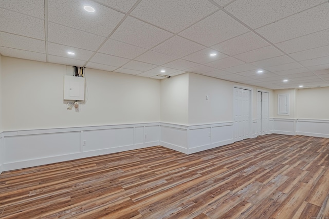 basement featuring hardwood / wood-style flooring and a paneled ceiling