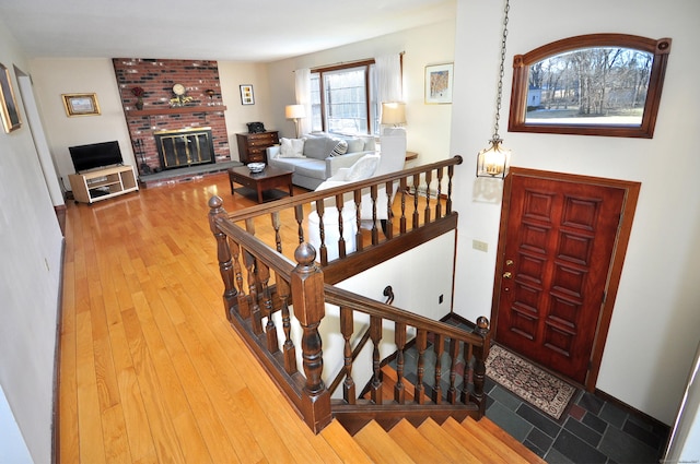 entryway with hardwood / wood-style flooring and a brick fireplace