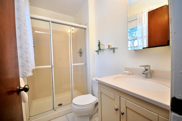 bathroom featuring vanity, tile patterned floors, a shower with door, and toilet