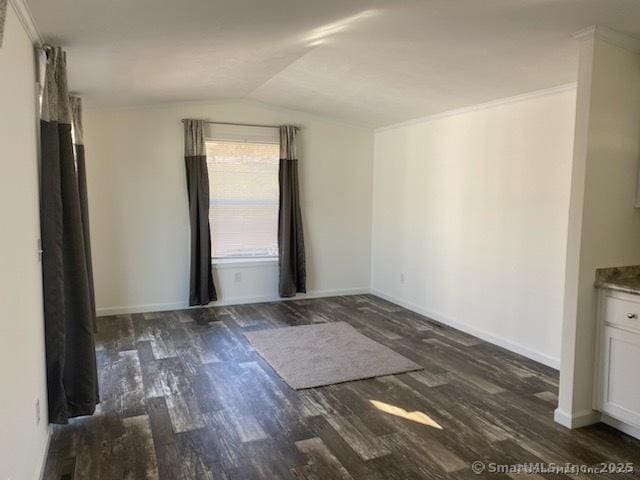 spare room featuring crown molding, lofted ceiling, and dark hardwood / wood-style flooring