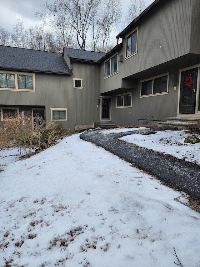 view of snow covered back of property