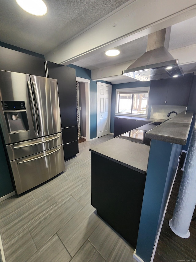 kitchen featuring island exhaust hood, a textured ceiling, and stainless steel fridge with ice dispenser