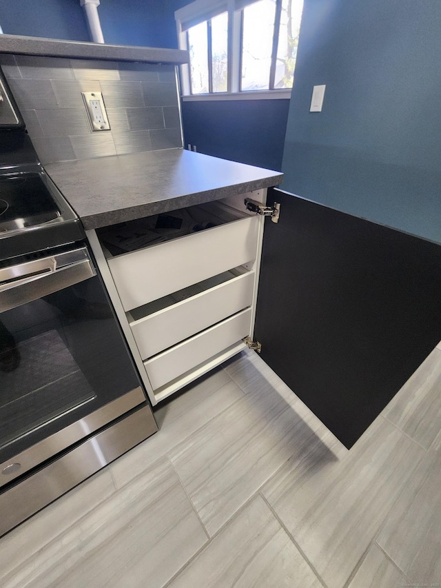 kitchen featuring backsplash and stainless steel electric range oven