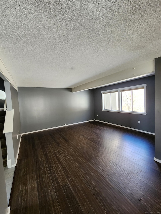 unfurnished room with dark hardwood / wood-style floors and a textured ceiling