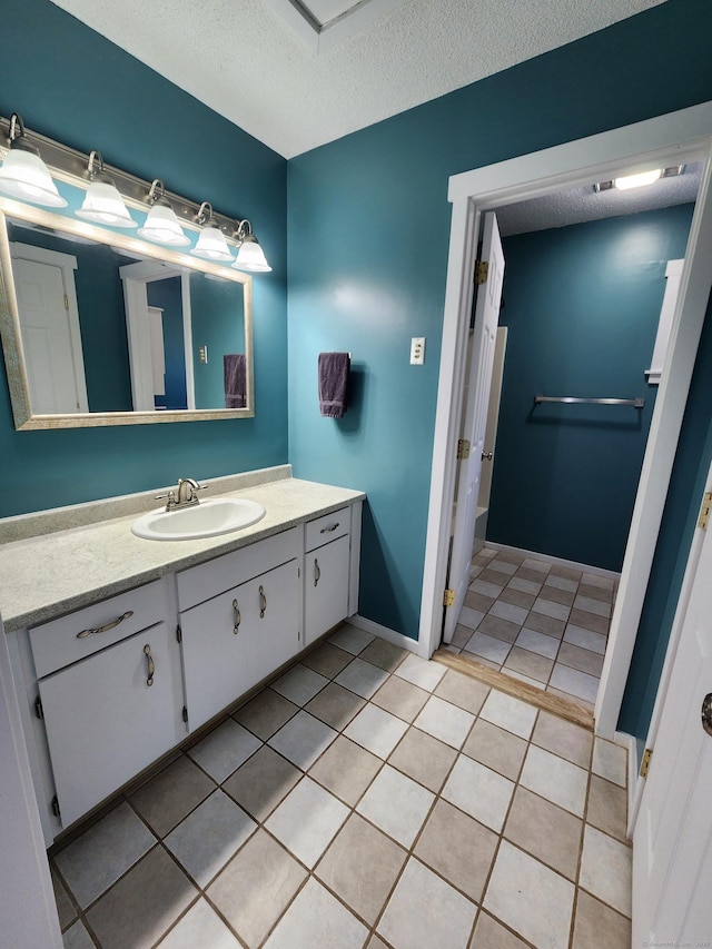 bathroom featuring vanity, tile patterned floors, and a textured ceiling