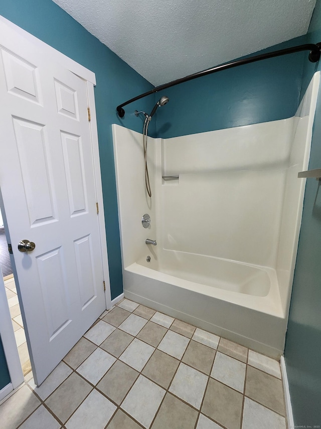 bathroom with tub / shower combination, tile patterned flooring, and a textured ceiling