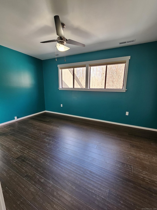 spare room with dark hardwood / wood-style flooring and ceiling fan