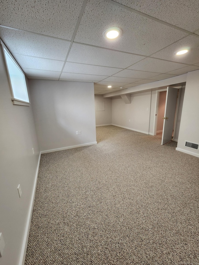 basement featuring carpet floors and a drop ceiling