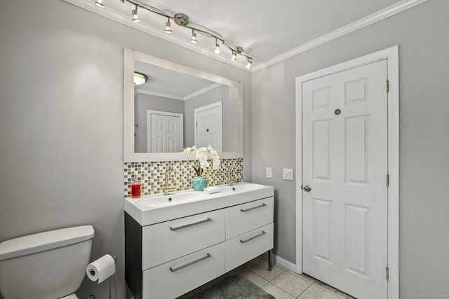 bathroom with tile patterned floors, toilet, crown molding, vanity, and decorative backsplash