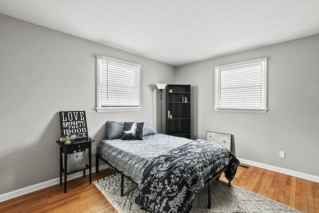 bedroom with multiple windows and hardwood / wood-style floors